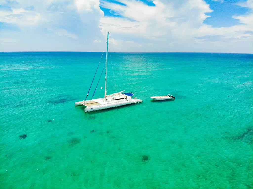 Catamaran rental in Cancun sailing across turquoise Caribbean waters, offering a private way to cruise, swim, and explore near Isla Mujeres.